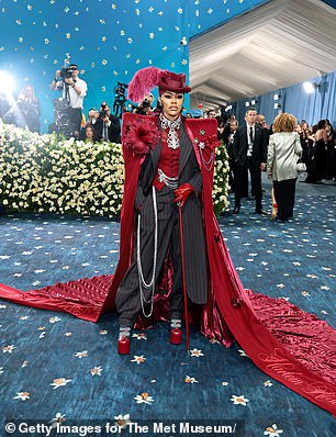 Teyana Taylor made a dramatic arrival in a burgundy and black suit and cape، complete with a feathered hat