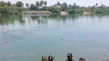 غواصو الشرطة في نهر الكوفة يستخرجون جثة شخص غارق.