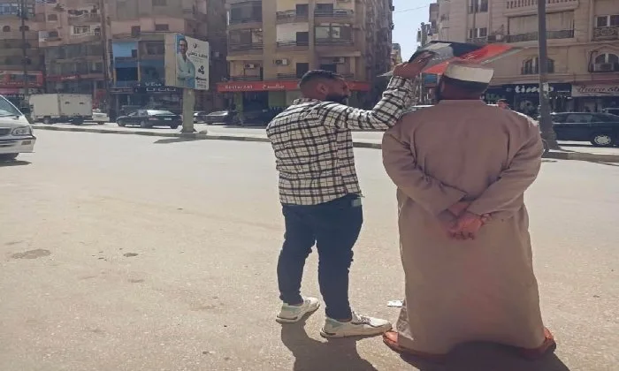لقطة إنسانية مؤثرة تشعل مواقع التواصل: شاب يظلل والده من أشعة الشمس بالفيوم