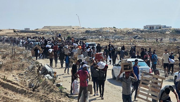 نازحون فلسطينيون يسيرون على طريق لاستلام مساعدات إنسانية من مؤسسة تدعمها أمريكا 